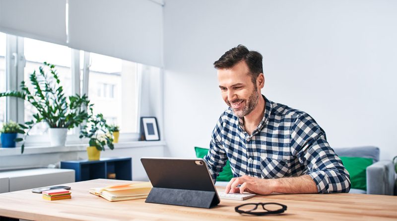 Image of a man working in front of a laptop on a desk in home environment to support remote work article