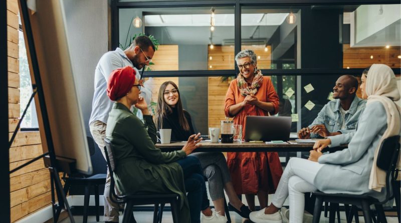 A diverse group of employees collaborating at a workplace meeting, reflecting diversity, equity and inclusion in the workplace.