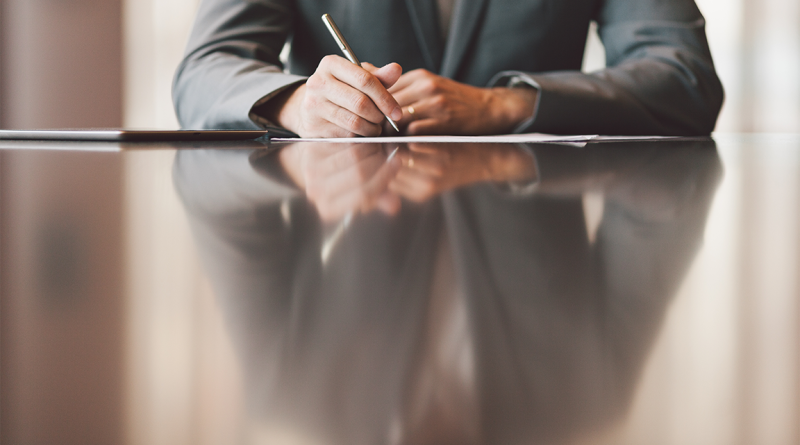 Business professional sat at desk in suit to support COO to CEO article