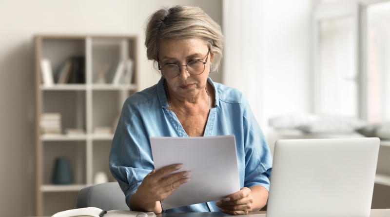 A professional reviewing documents at her desk, symbolizing the process of crafting a vision statement with clarity and purpose.