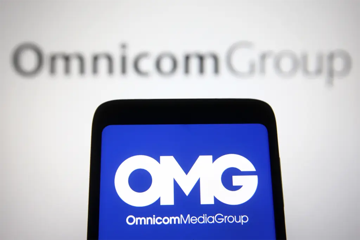 Omnicom logo on phone screen to support Omnicom and Interpublic merger article