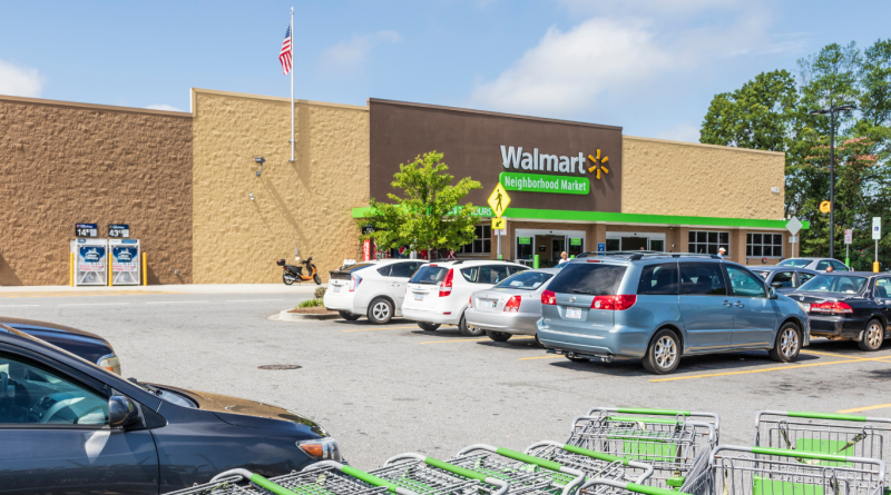 Walmart Neighborhood Market storefront, a successful family business, with parked cars and shopping carts.