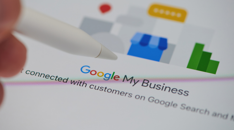 Close-up of a stylus pointing to a Google My Business listing on a screen, showing tools for boosting local SEO and online visibility.