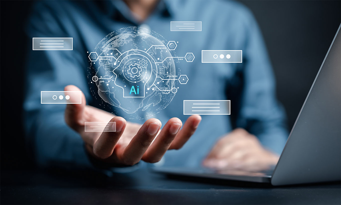 A business professional holds a glowing digital interface with an AI icon, symbolizing artificial intelligence innovation and global data connectivity, while working on a laptop.