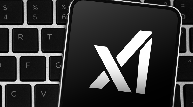 Close-up of a smartphone displaying the xAI logo in white on a black screen, resting on a computer keyboard.