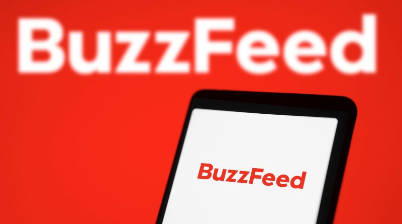 BuzzFeed logo displayed on a smartphone screen beside social media and digital publishing graphics